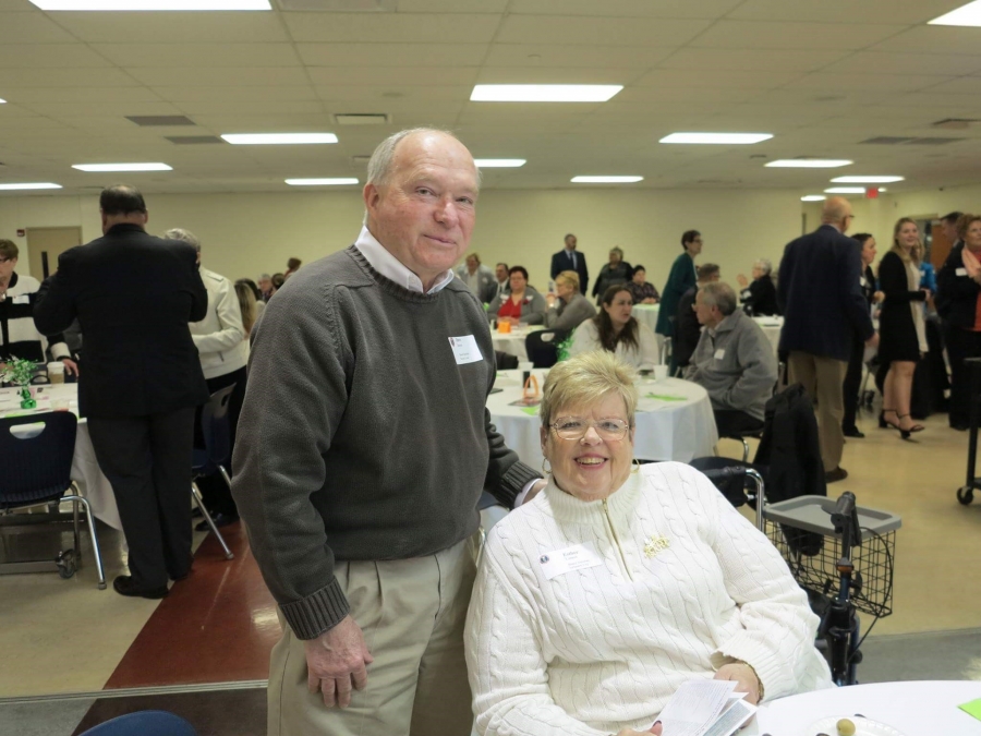 man standing and woman sitting at a table